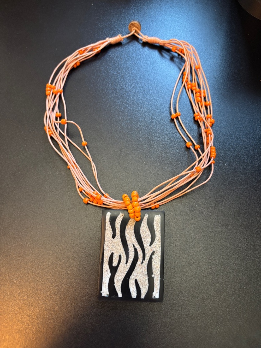 Multi-Strand Orange Bead Necklace with Zebra Pendant